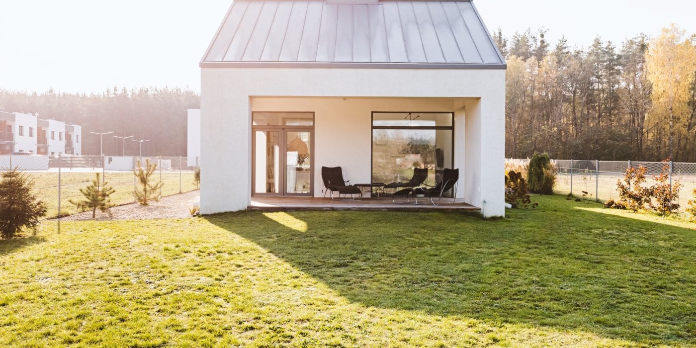 Modern garden furniture on the terrace of stylish suburban house with big green yard