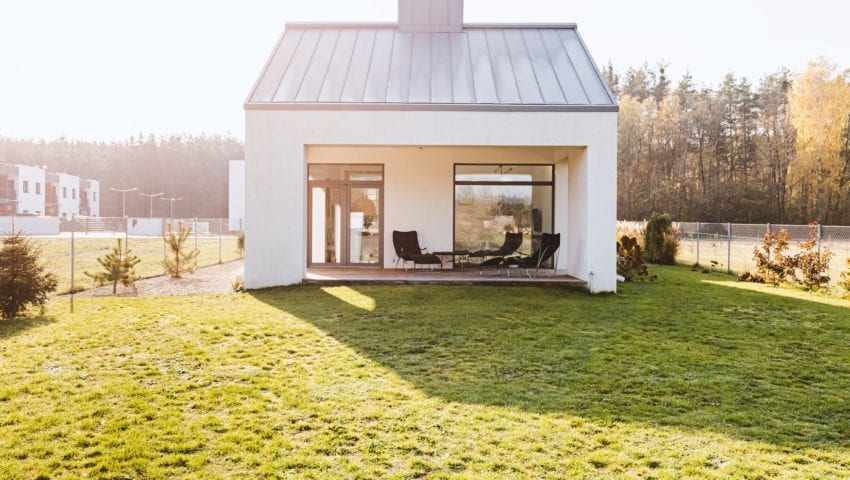 Modern garden furniture on the terrace of stylish suburban house with big green yard